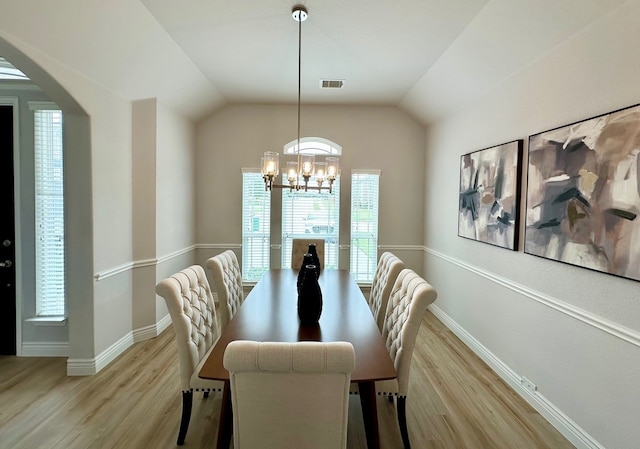 dining room with baseboards, vaulted ceiling, an inviting chandelier, and wood finished floors