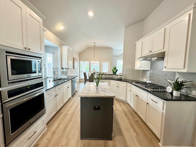 kitchen with stainless steel appliances, backsplash, light wood-style floors, a sink, and under cabinet range hood