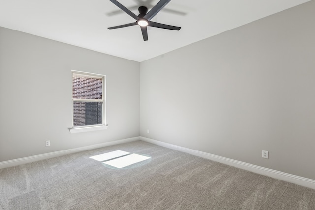 spare room featuring carpet floors, a ceiling fan, and baseboards