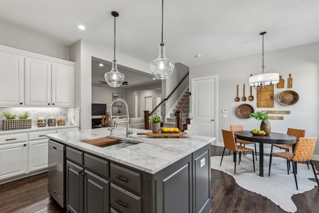 kitchen featuring dark wood-style floors, white cabinets, a sink, and dishwasher