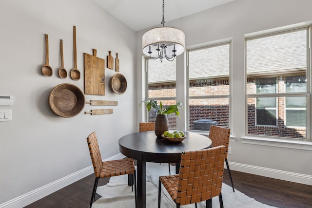 dining room featuring a notable chandelier, baseboards, and wood finished floors