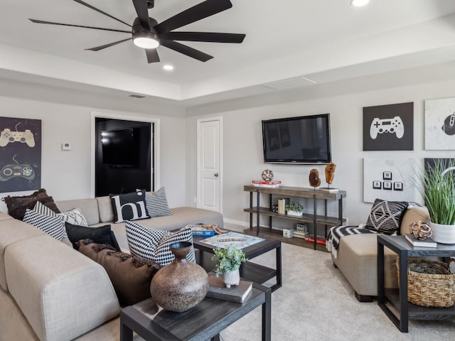 living room featuring a ceiling fan, recessed lighting, visible vents, and a tray ceiling