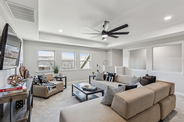 living room featuring baseboards, visible vents, a raised ceiling, ceiling fan, and carpet floors