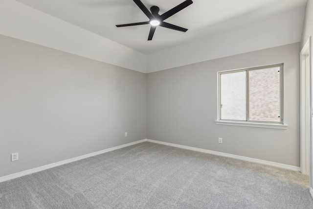 carpeted empty room featuring baseboards and a ceiling fan