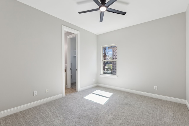 empty room with a ceiling fan, light carpet, and baseboards