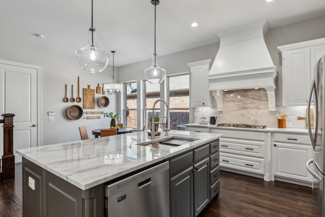 kitchen with custom exhaust hood, a sink, white cabinets, and stainless steel appliances