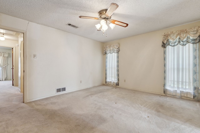 spare room featuring a healthy amount of sunlight, visible vents, and carpet flooring