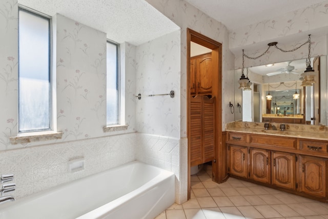 full bathroom with wallpapered walls, vanity, a textured ceiling, tile patterned flooring, and a bath