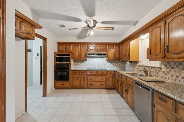 kitchen with brown cabinets, visible vents, decorative backsplash, a sink, and black appliances