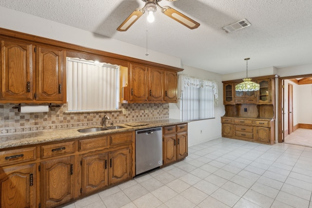 kitchen featuring stainless steel dishwasher, a sink, visible vents, and brown cabinets