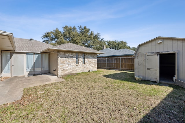 view of yard with an outbuilding, fence, and a shed