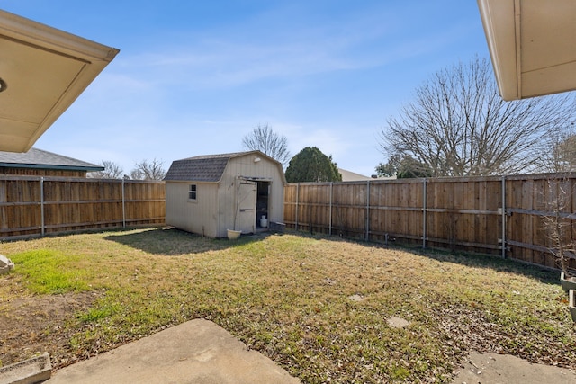 view of yard featuring an outbuilding, a fenced backyard, and a storage shed