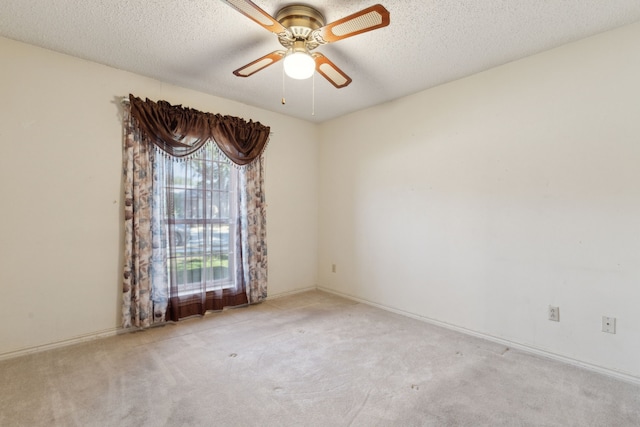 carpeted spare room with a ceiling fan, a textured ceiling, and baseboards