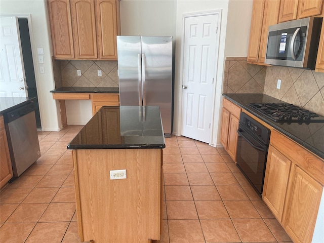 kitchen with dark stone counters, black appliances, light tile patterned flooring, and a kitchen island