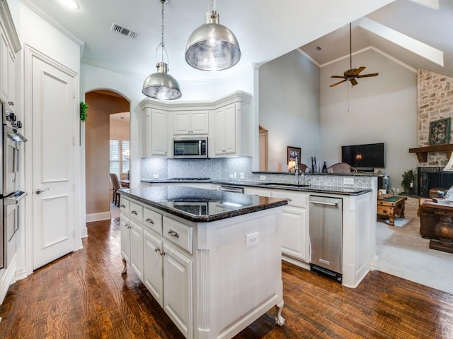 kitchen with visible vents, white cabinets, arched walkways, appliances with stainless steel finishes, and open floor plan