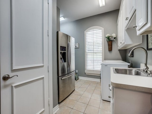 kitchen with light tile patterned floors, light countertops, white cabinetry, a sink, and stainless steel fridge with ice dispenser