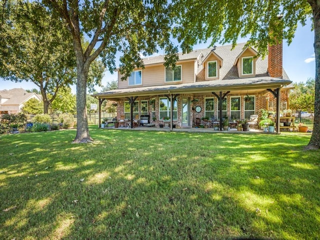 back of property featuring brick siding, a lawn, a chimney, and fence