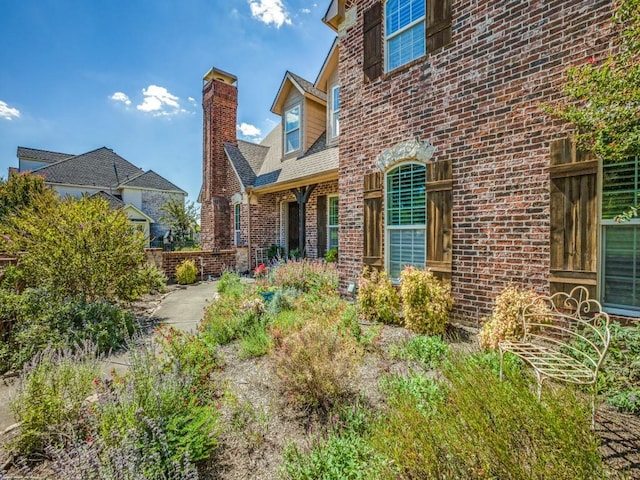 doorway to property with brick siding and a chimney