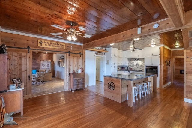 kitchen with a barn door, wooden ceiling, and a ceiling fan