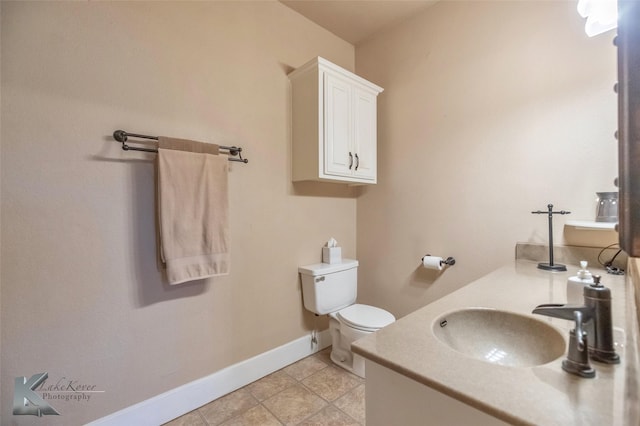 bathroom featuring tile patterned flooring, toilet, vanity, and baseboards