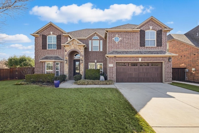 traditional-style home with a front yard, concrete driveway, brick siding, and fence