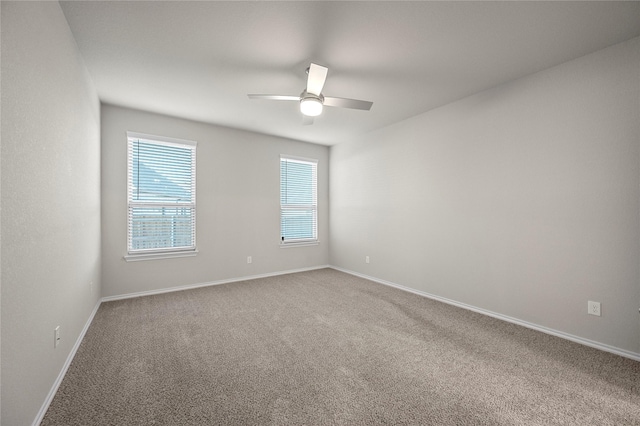 spare room with a ceiling fan, baseboards, and carpet flooring