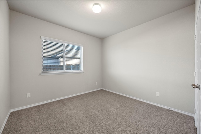 spare room featuring carpet floors and baseboards