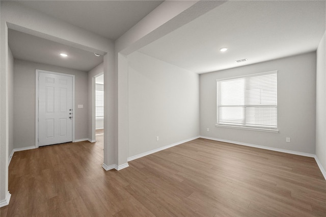 unfurnished room featuring recessed lighting, visible vents, baseboards, and wood finished floors