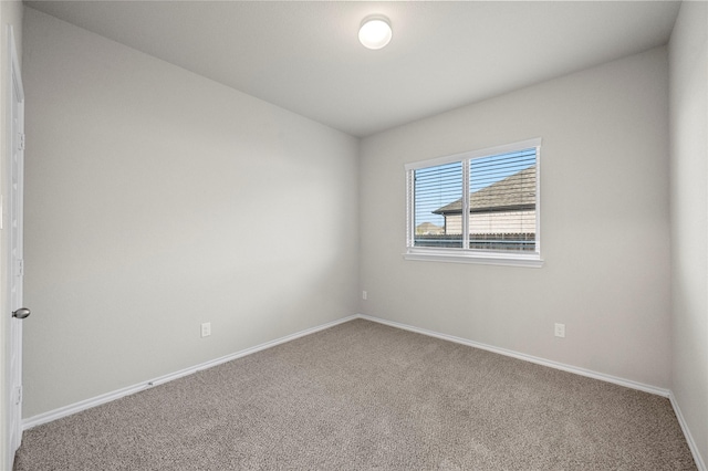 unfurnished room with carpet floors and baseboards