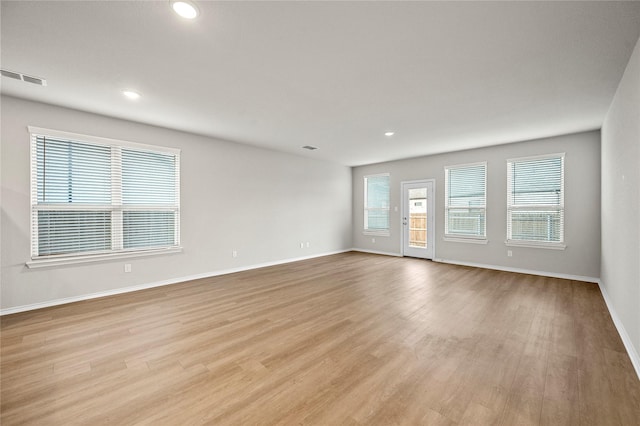 unfurnished room with light wood finished floors, baseboards, visible vents, and recessed lighting