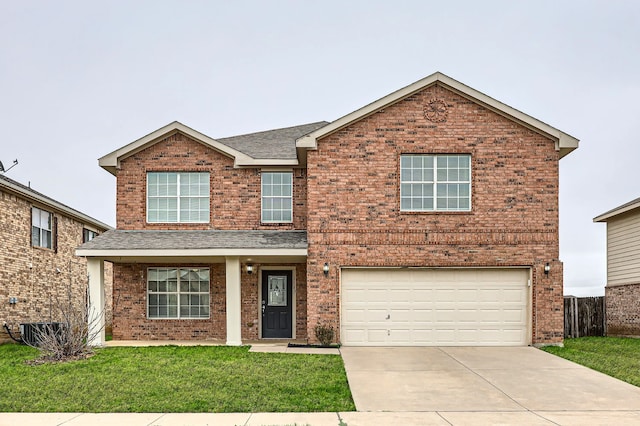 traditional-style home with driveway, a front yard, and brick siding