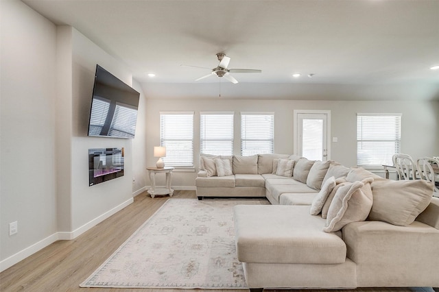 living room with a healthy amount of sunlight, light wood-style flooring, and baseboards