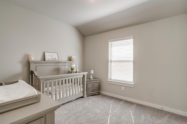 bedroom featuring light carpet, a nursery area, lofted ceiling, and baseboards