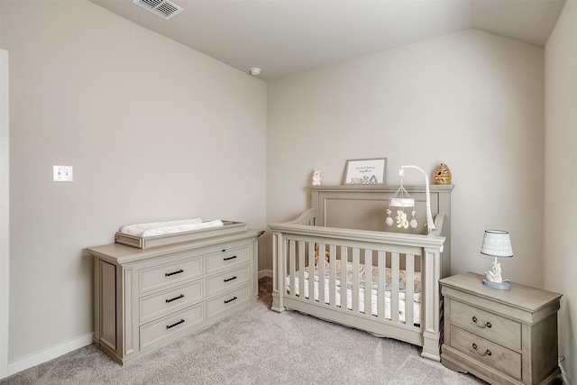 bedroom featuring light colored carpet, visible vents, vaulted ceiling, a crib, and baseboards