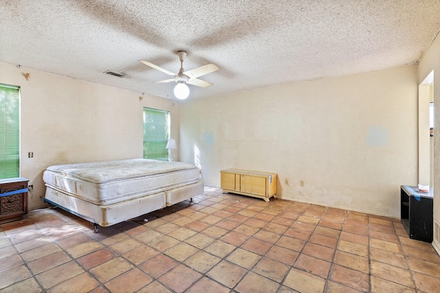 bedroom with visible vents, ceiling fan, and a textured ceiling