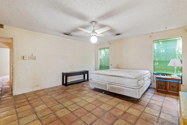 bedroom featuring multiple windows, visible vents, and a textured ceiling