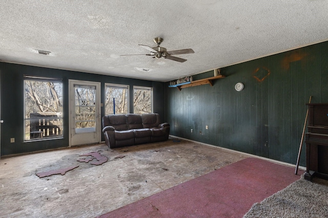 living area featuring visible vents, ceiling fan, and a textured ceiling