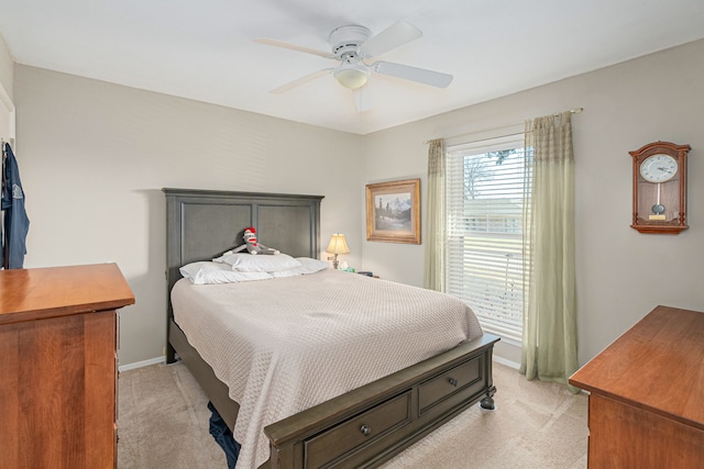 bedroom featuring a ceiling fan, light colored carpet, and baseboards