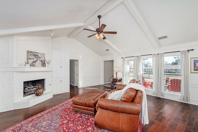 living room featuring visible vents, a ceiling fan, dark wood-style flooring, a fireplace, and beam ceiling