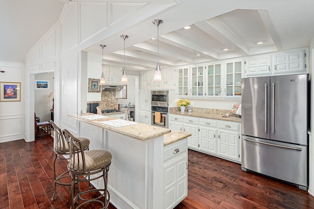 kitchen with a peninsula, dark wood-style flooring, appliances with stainless steel finishes, light stone countertops, and glass insert cabinets