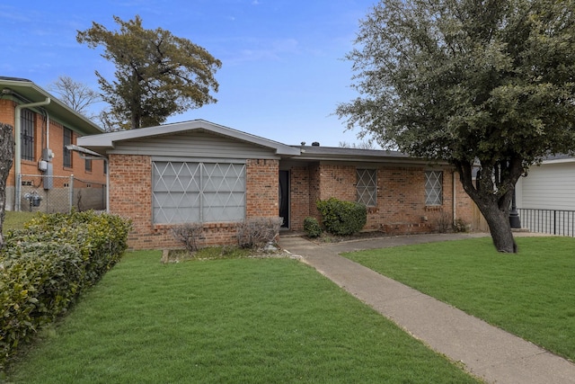 ranch-style house with an attached garage, a front yard, fence, and brick siding