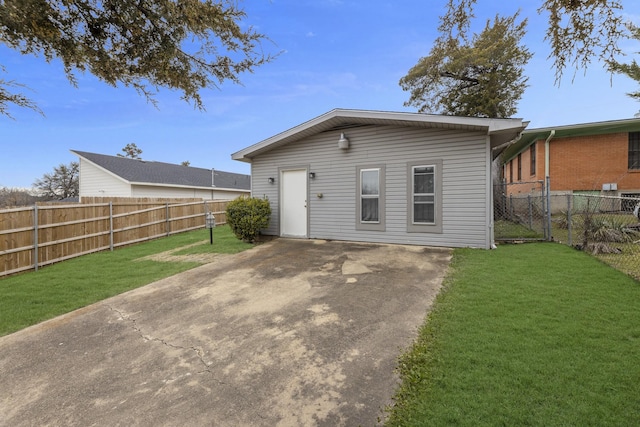 rear view of property featuring a patio area, a yard, and a fenced backyard