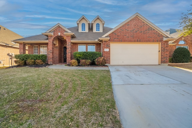 view of front facade with an attached garage, concrete driveway, brick siding, and a front yard