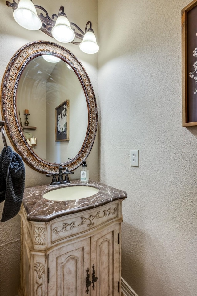 bathroom with a textured wall and vanity