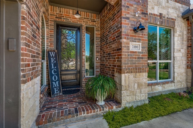 doorway to property with stone siding and brick siding