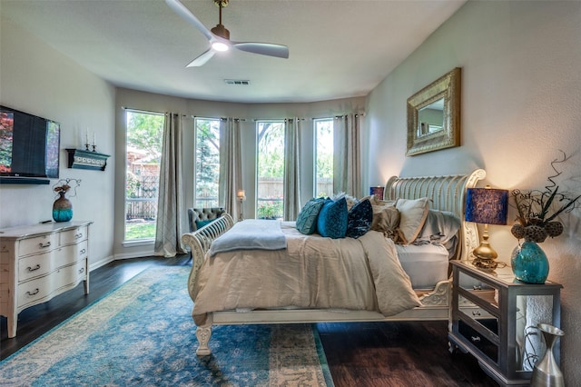 bedroom with baseboards, visible vents, multiple windows, and wood finished floors