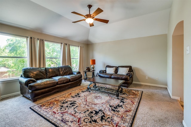 carpeted living room featuring arched walkways, ceiling fan, vaulted ceiling, and a healthy amount of sunlight