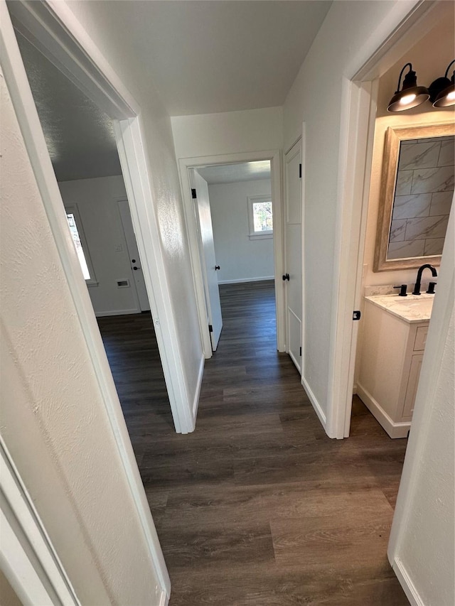 hall with dark wood finished floors and baseboards