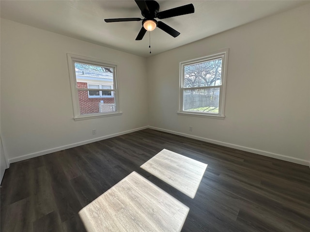 unfurnished room with dark wood-style flooring, ceiling fan, and baseboards