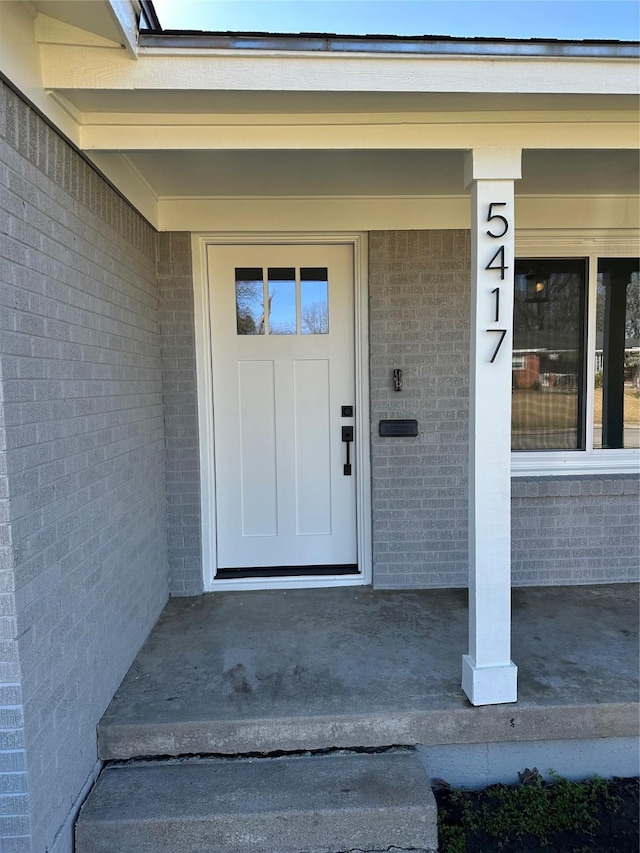 property entrance featuring brick siding